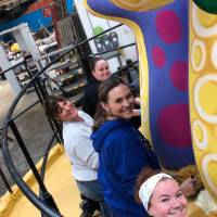 Four women smiling on parade float